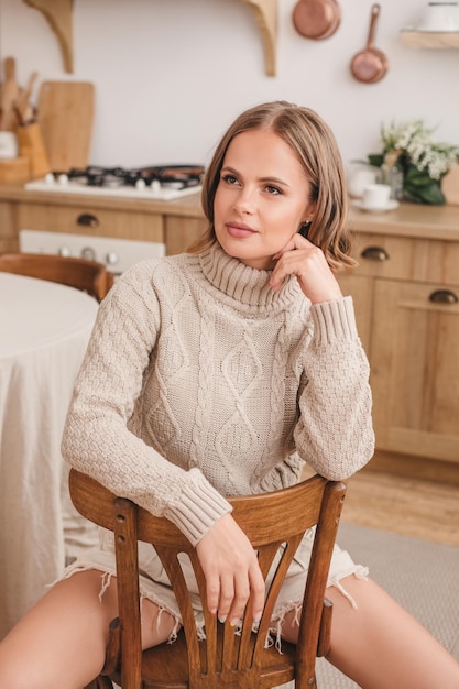 bella mujer sentada en la cocina y sonriendo