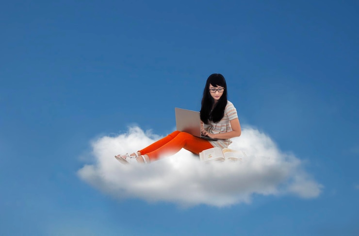 Foto bella mujer sentada con una computadora portátil en la nube