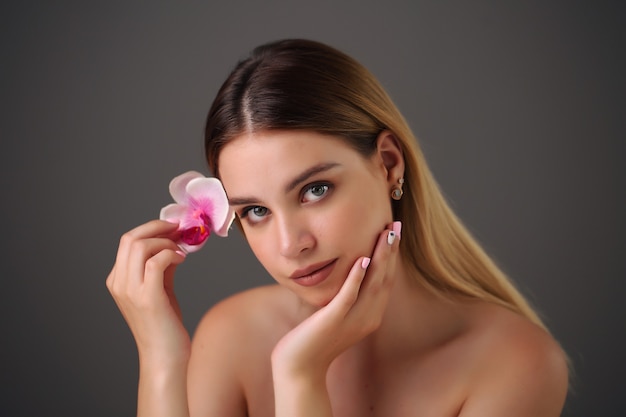 Bella mujer sonriente con orquídea