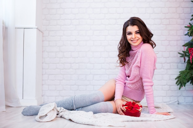 Bella mujer sonriente con regalos en casa