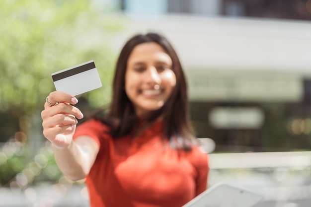 Foto bella mujer sonriente con tarjeta de crédito tableta digital enfoque selectivo en la mano tecnología