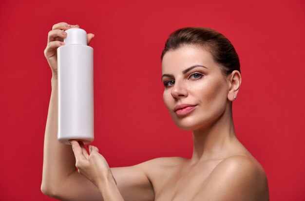 Foto bella mujer sosteniendo la botella de champú