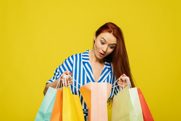 Una bella mujer sostiene paquetes y compras