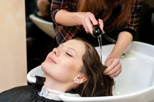 Bella mujer con su cabello lavado en el salón de belleza