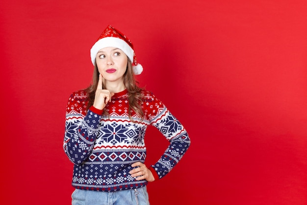 Bella mujer con un suéter y un gorro de Papá Noel