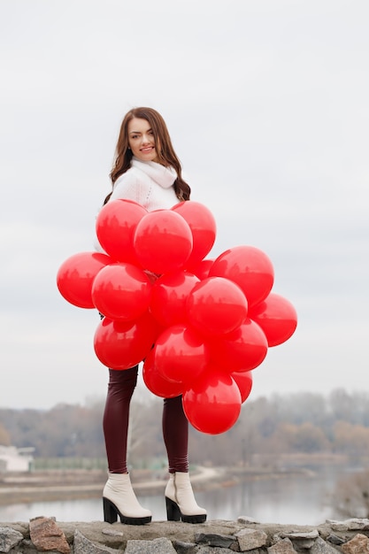 Bella mujer tiene globos en sus manos