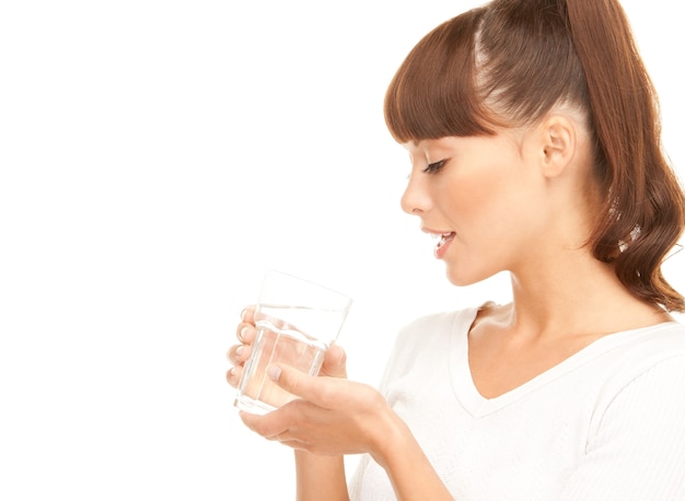 Bella mujer con un vaso de agua sobre blanco