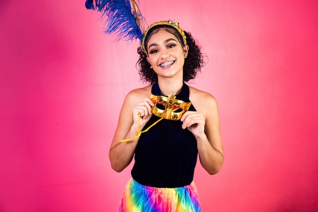 Bella mujer vestida para la noche de carnaval. Mujer afro con maquillaje de carnaval