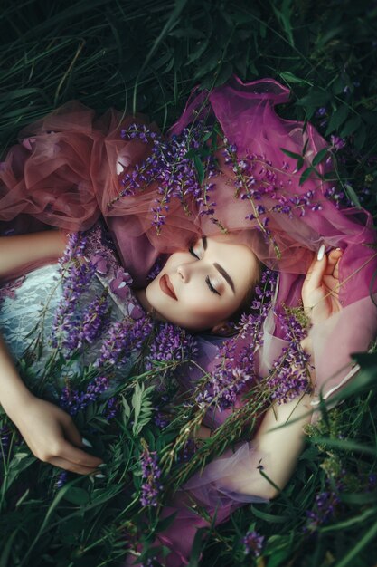 Bella mujer con vestido elegante posando con flores