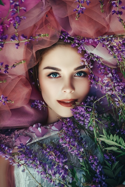 Bella mujer con vestido elegante posando con flores