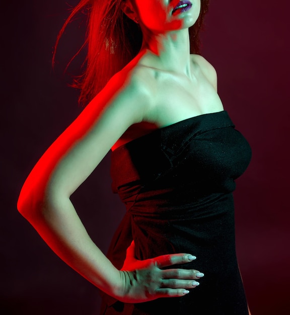 Bella mujer con un vestido negro con luces de estudio