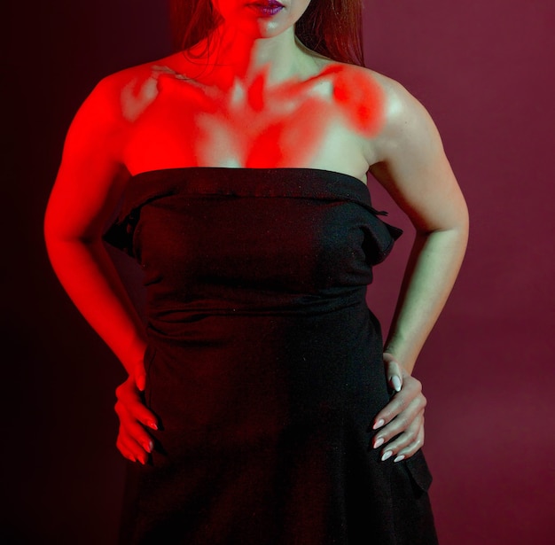 Bella mujer con un vestido negro con luces de estudio