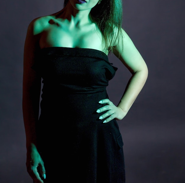 Bella mujer con un vestido negro con luces de estudio