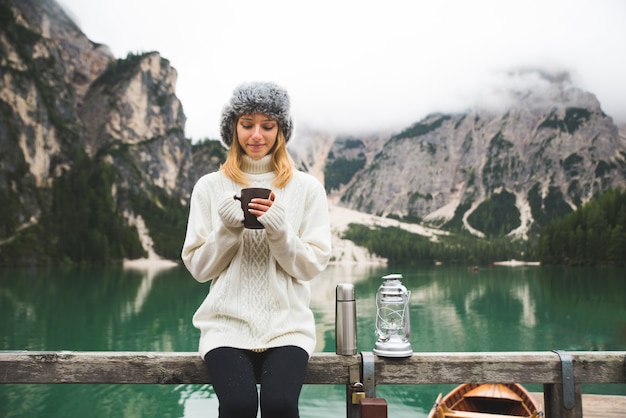 Bella mujer visitando un lago alpino en Braies, Italia