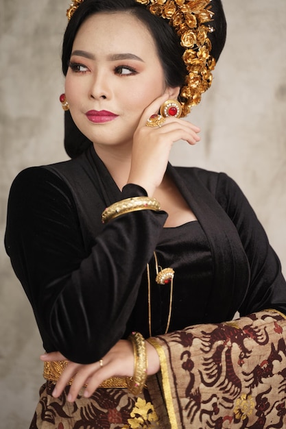Bella mujer vistiendo joyas de la corona de payas y kebaya balinesa