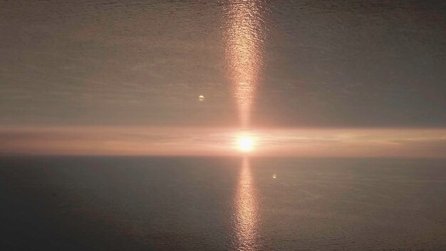 Bella puesta de sol en el mar con un efecto de horizonte de espejo sol de la tarde en el horizonte con resplandores