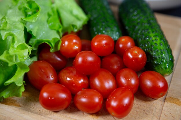 Bellamente distribuidas verduras brillantes y deliciosas en una tabla de cortar