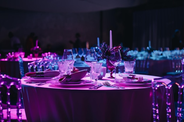 Bellamente organizado evento mesa redonda servida banquete listo para los invitados mesa redonda decorada con platos vacíos vasos horquillas servilleta elegante mesa de cena