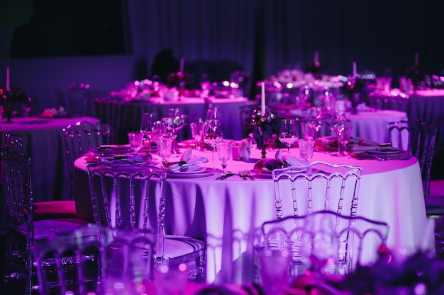 Bellamente organizado evento mesa redonda servida banquete listo para los invitados mesa redonda decorada con platos vacíos vasos horquillas servilleta elegante mesa de cena