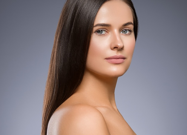 Belleza cara mujer joven y bella niña Hermosa mujer retrato cabello castaño. Chica adulta joven con maquillaje de ojos de moda de piel sana. Tiro del estudio.