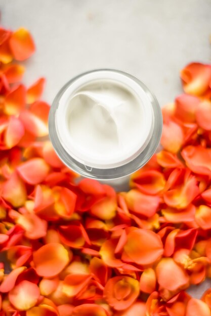 Belleza crema hidratante facial y pétalos de flores en mármol producto cosmético de lujo