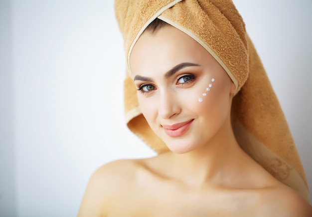 Belleza y cuidado, feliz sonriente joven mujer tiene crema para la cara