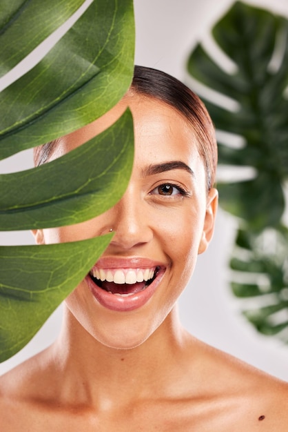 Foto belleza para el cuidado de la piel y retrato de mujer con planta en estudio para bienestar, lujo y spa maquillaje para el cuidado del cuerpo y niña con sonrisa en la cara para productos de belleza natural, cosméticos y productos para el cuidado de la piel