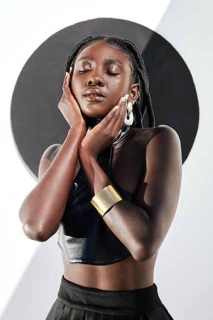 La belleza es un trabajo interior. Foto de una joven atractiva posando con un traje negro contra una pared con un círculo.