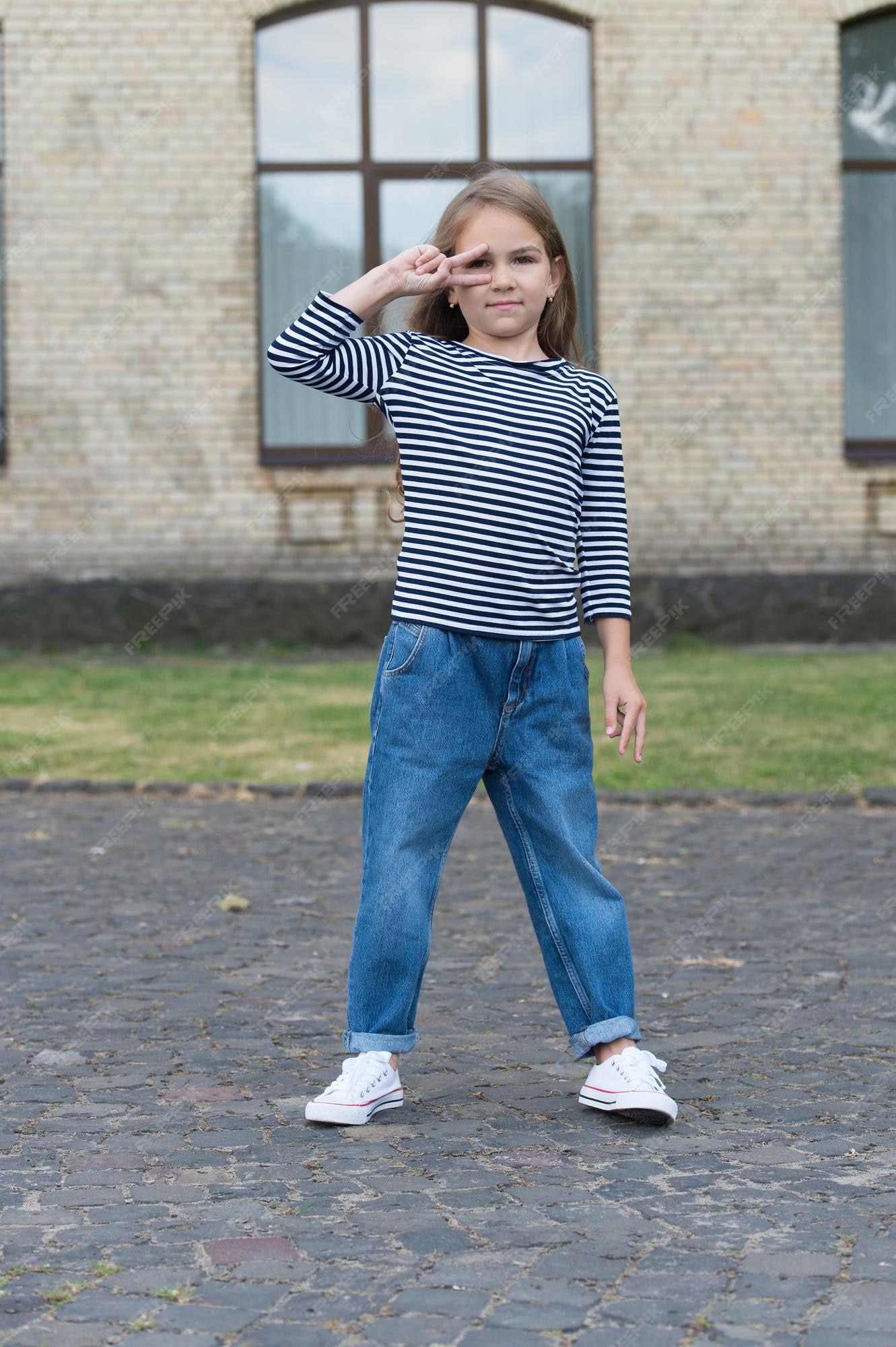 funky fresca el niño pequeño muestra el signo de la mano de la paz al aire libre lleva un estilo casual estilo de niña de moda tienda de ropa ropa para