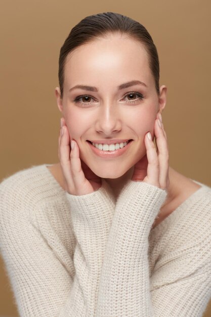Belleza de invierno o retrato de mujer natural en estudio aislada en fondo marrón para moda o bienestar Cuidado de la piel del rostro y relajarse con modelo confiado o persona feliz en camiseta o suéter de lana