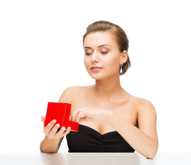 Belleza y joyería - mujer con aretes de diamantes y caja de regalo.