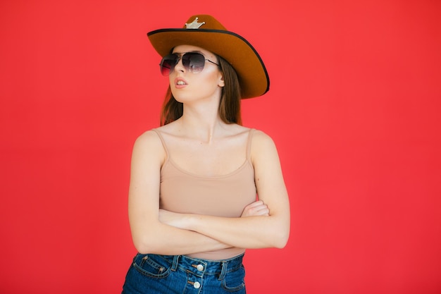 Belleza juguetona en estilo campestre Hermosa mujer joven con sombrero de vaquero