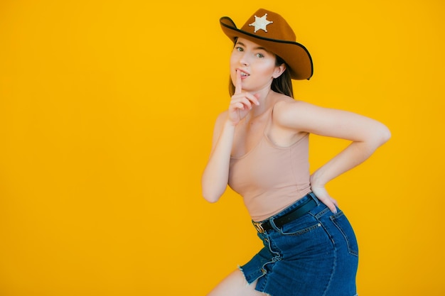 Belleza juguetona en estilo campestre Hermosa mujer joven con sombrero de vaquero