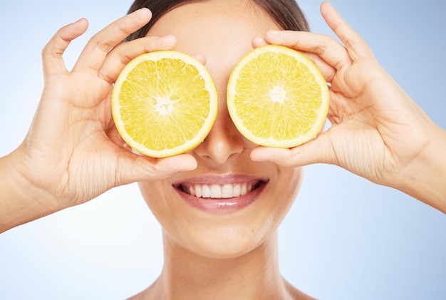 Belleza limón y mujer con cara y producto natural desintoxicación facial orgánica y vegana para la piel contra el fondo del estudio Manos dientes y labios cuidado cosmético con cítricos y vitamina c para el cuidado de la piel