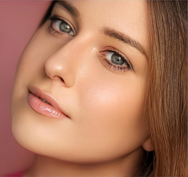 Belleza maquillaje y cuidado de la piel cosméticos modelo cara retrato sobre fondo rosa hermosa mujer con maquillaje natural piel sana perfecta brillo cuidado facial