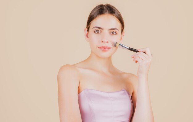 Belleza mujer cara piel sana con maquillaje natural modelo de belleza fresca con pincel de maquillaje hermosa f