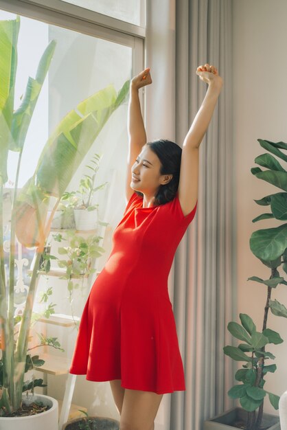 Belleza mujer embarazada estirando su mano cerca de la ventana