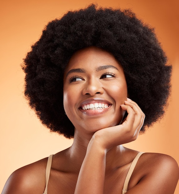 Belleza mujer negra y bienestar feliz maquillaje estético o natural cuidado de la piel brillante y cosméticos limpios sobre fondo de estudio naranja Sonrisa joven modelo cara cabello afro o inspiración para pensar