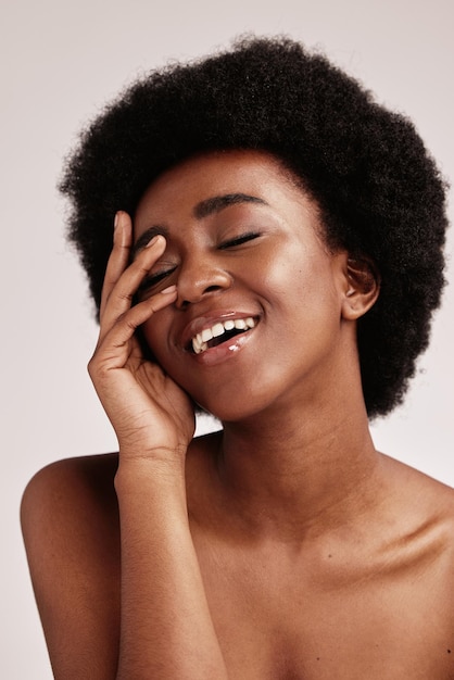 Belleza mujer negra y cuidado de la piel de una persona joven cara con las manos felices por los cosméticos de bienestar facial y modelo en un estudio aislado con una sonrisa haciendo desintoxicación dermatológica y autocuidado de spa