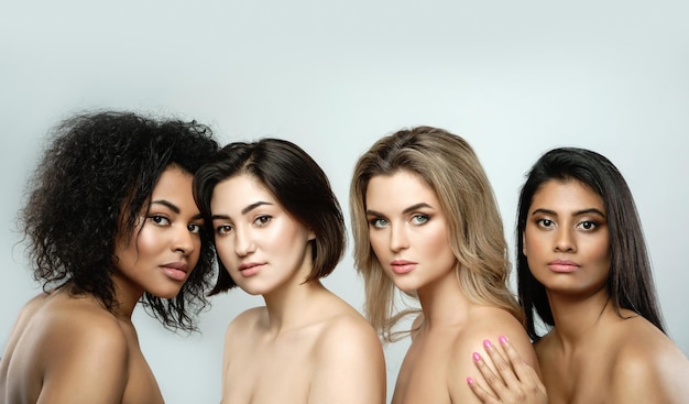 Belleza multiétnica y amistad Grupo de hermosas mujeres de diferentes etnias sobre fondo gris