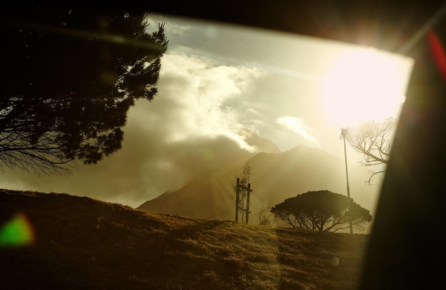 La belleza de la naturaleza Un atardecer detrás de montañas nubladas