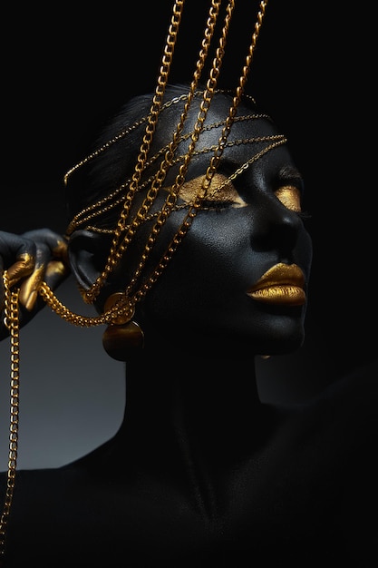 Belleza oro maquillaje labios párpados mujer negro piel color cuerpo arte oro joyería cadena puntas de los dedos uñas en color oro pintura profesional oro maquillaje