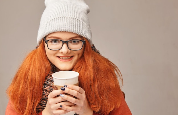 Belleza pelirroja feliz con una taza de café