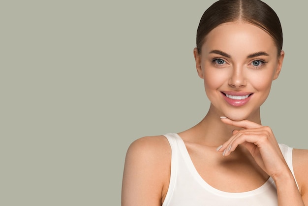 Belleza piel sana mujeres tocando cara retrato de estudio cosmético. Fondo de color de ropa deportiva verde