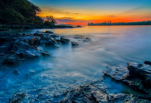 Belleza puesta de sol en la playa con coral a lo largo de la costa de la isla de Batam