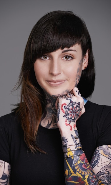 Belleza redefinida Un retrato de estudio recortado de una mujer joven tatuada
