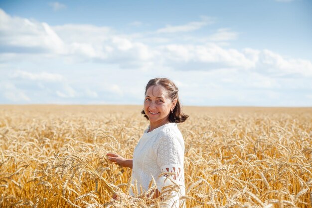 Belleza solitaria mujer madura camina en el campo de trigo horizontal photoxDxA