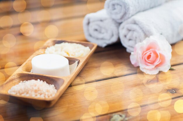 belleza, spa, cuidado del cuerpo, cosmética natural y concepto de baño: cierre de jabón con sal del Himalaya y exfoliación en un tazón de madera sobre la mesa