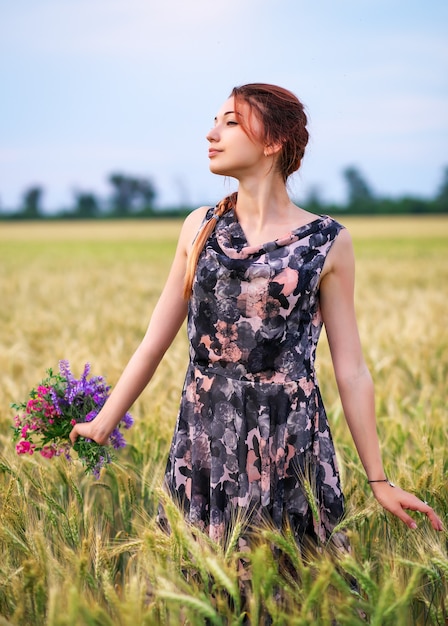 Bellezas al aire libre disfrutando de la naturaleza. Hermosa chica modelo adolescente en vestido en el campo de primavera