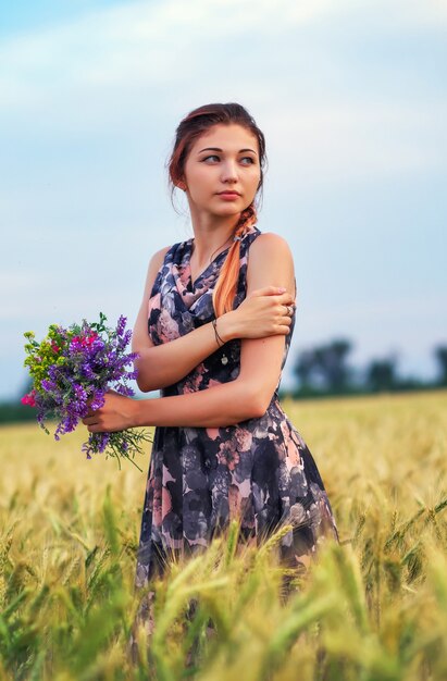 Bellezas al aire libre disfrutando de la naturaleza. Hermosa chica modelo adolescente en vestido en el campo de primavera